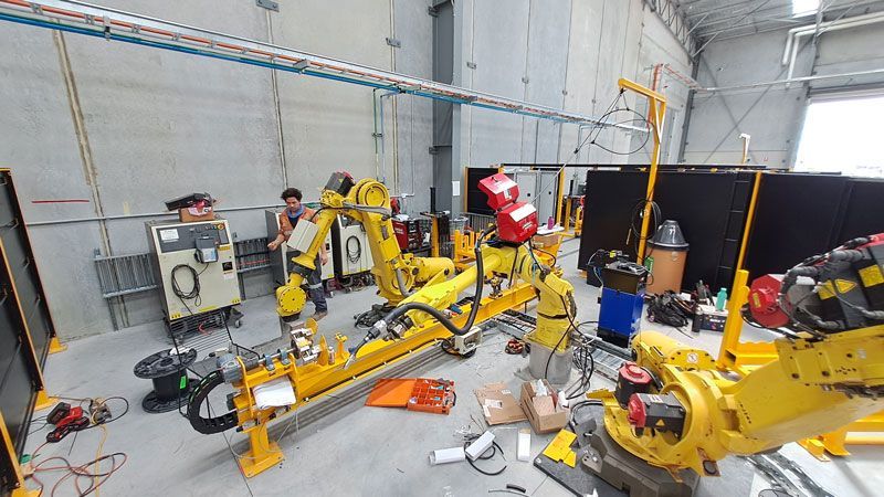 A bunch of yellow robots are sitting on the floor in a room — Industrial Automation Australia in Eag