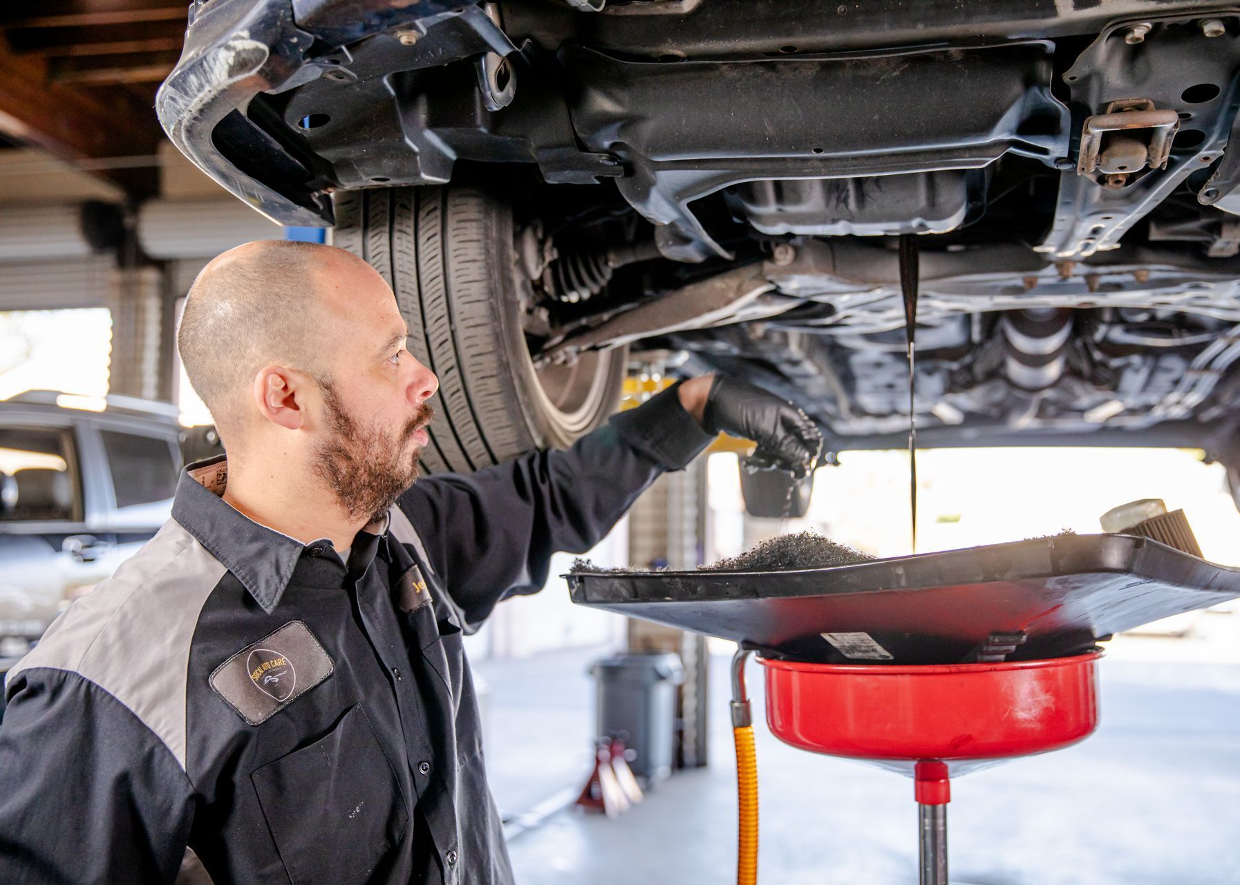A man is balancing a tire on a machine in a garage.
