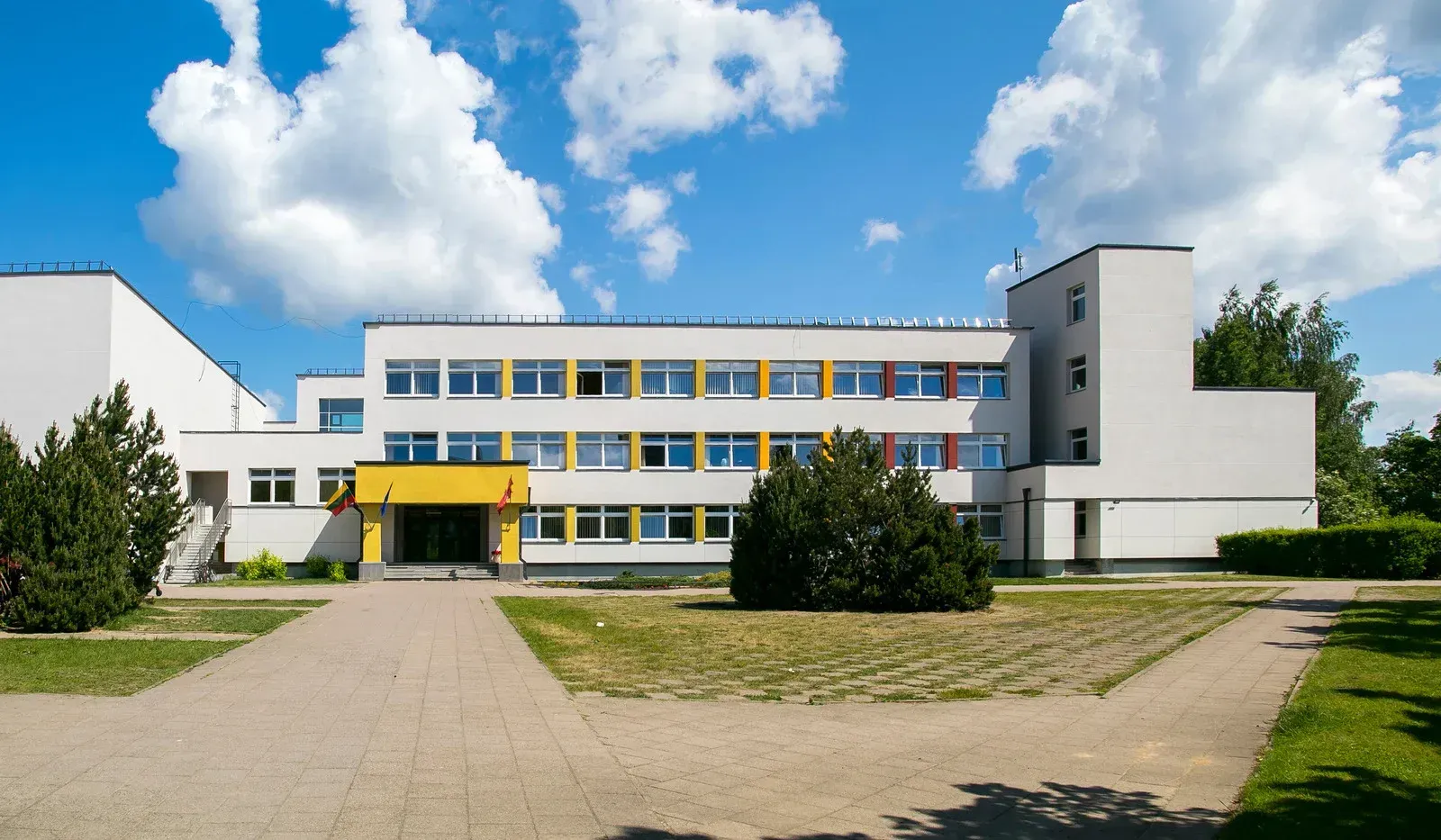 A large white and yellow building with a blue sky in the background