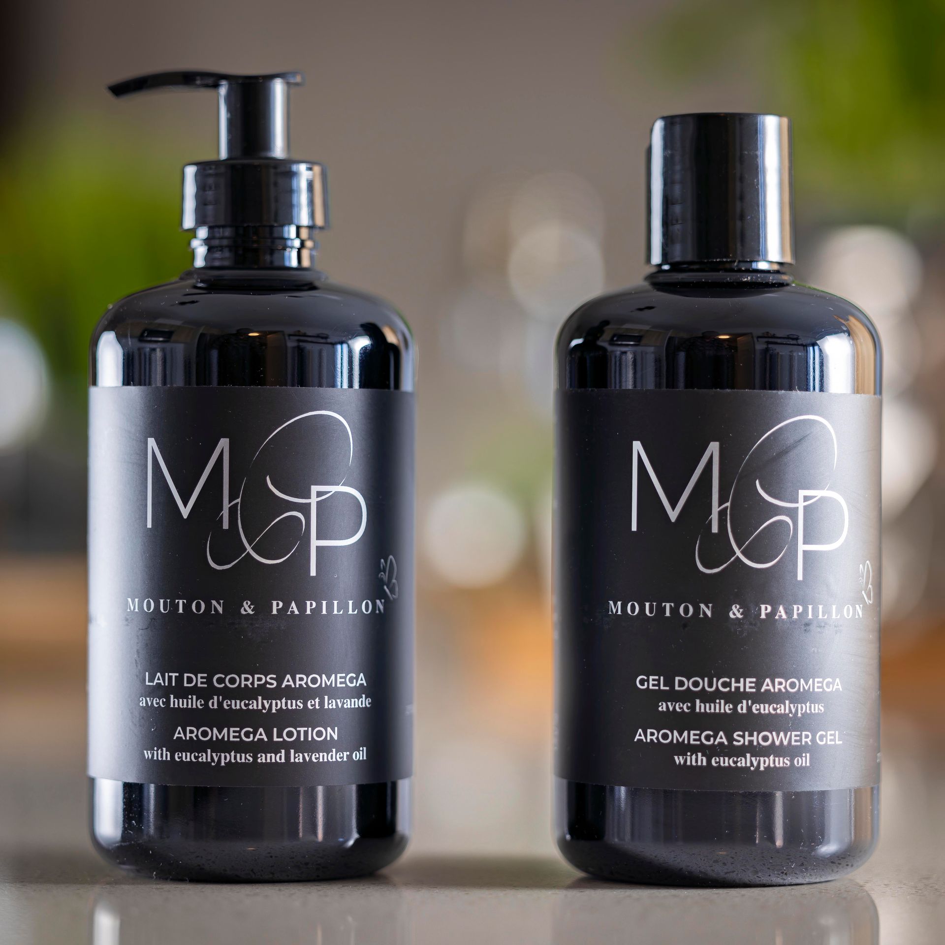 Deux bouteilles de savon sont posées l'une à côté de l'autre sur une table.