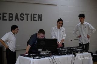 Un groupe de personnes travaille sur un ordinateur devant un panneau sur lequel est écrit sebastien.