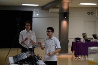 Deux hommes se tiennent l'un à côté de l'autre dans une pièce.