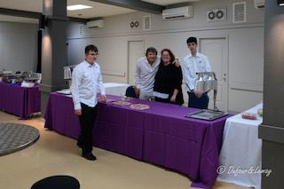 Un groupe de personnes pose pour une photo devant une table de buffet.