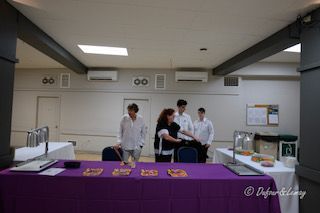 Un groupe de personnes debout autour d'une table violette dans une pièce.