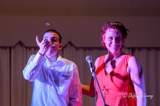 Un homme et une femme se tiennent l'un à côté de l'autre sur une scène avec un microphone.