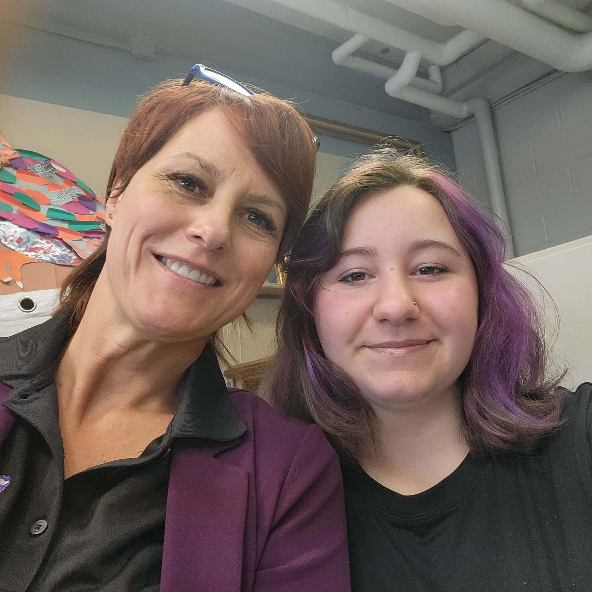 Une femme et une fille aux cheveux violets posent pour une photo.