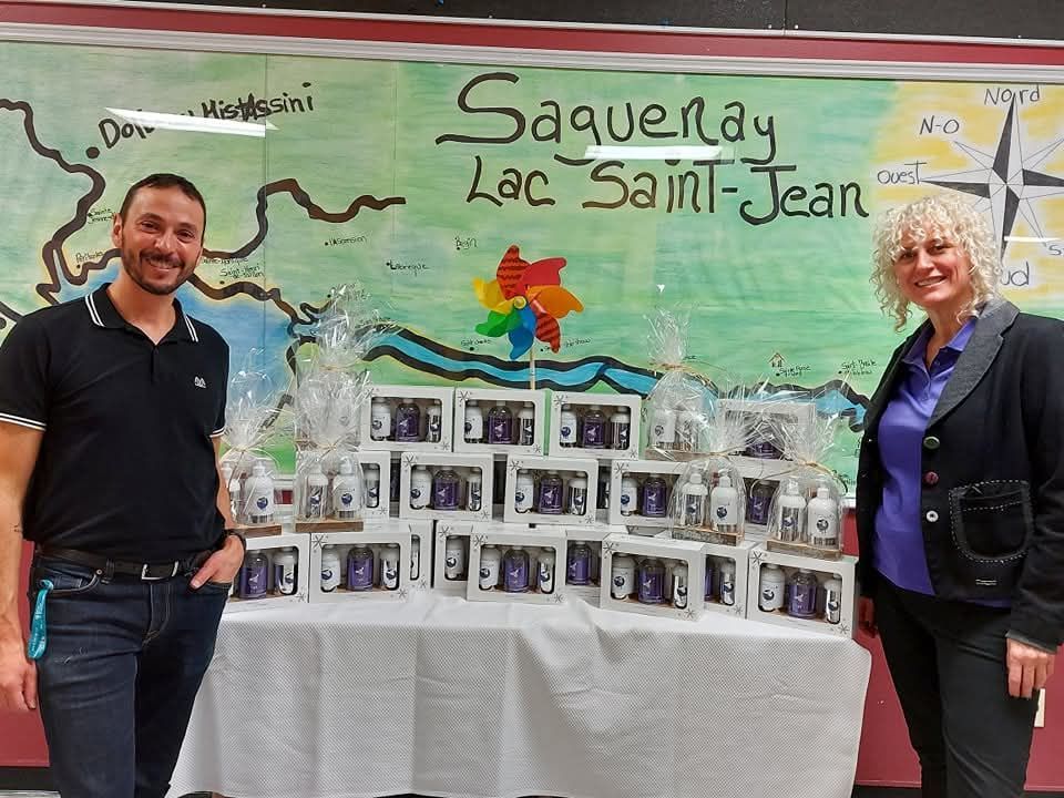 Un homme et une femme se tiennent devant un panneau indiquant Saquenay Lac Saint-Jean