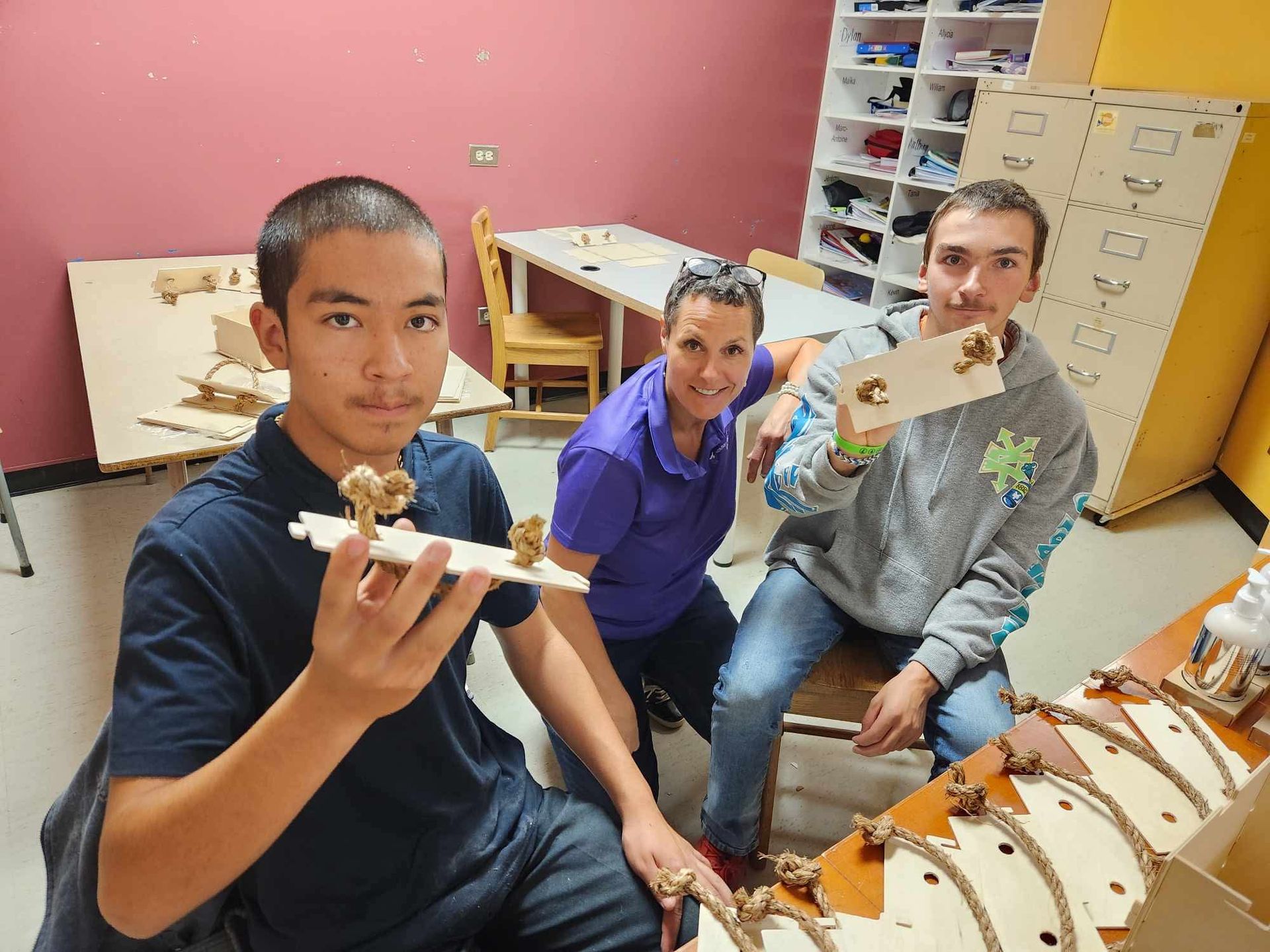 Un groupe de personnes sont assises autour d'une table tenant des morceaux de bois.