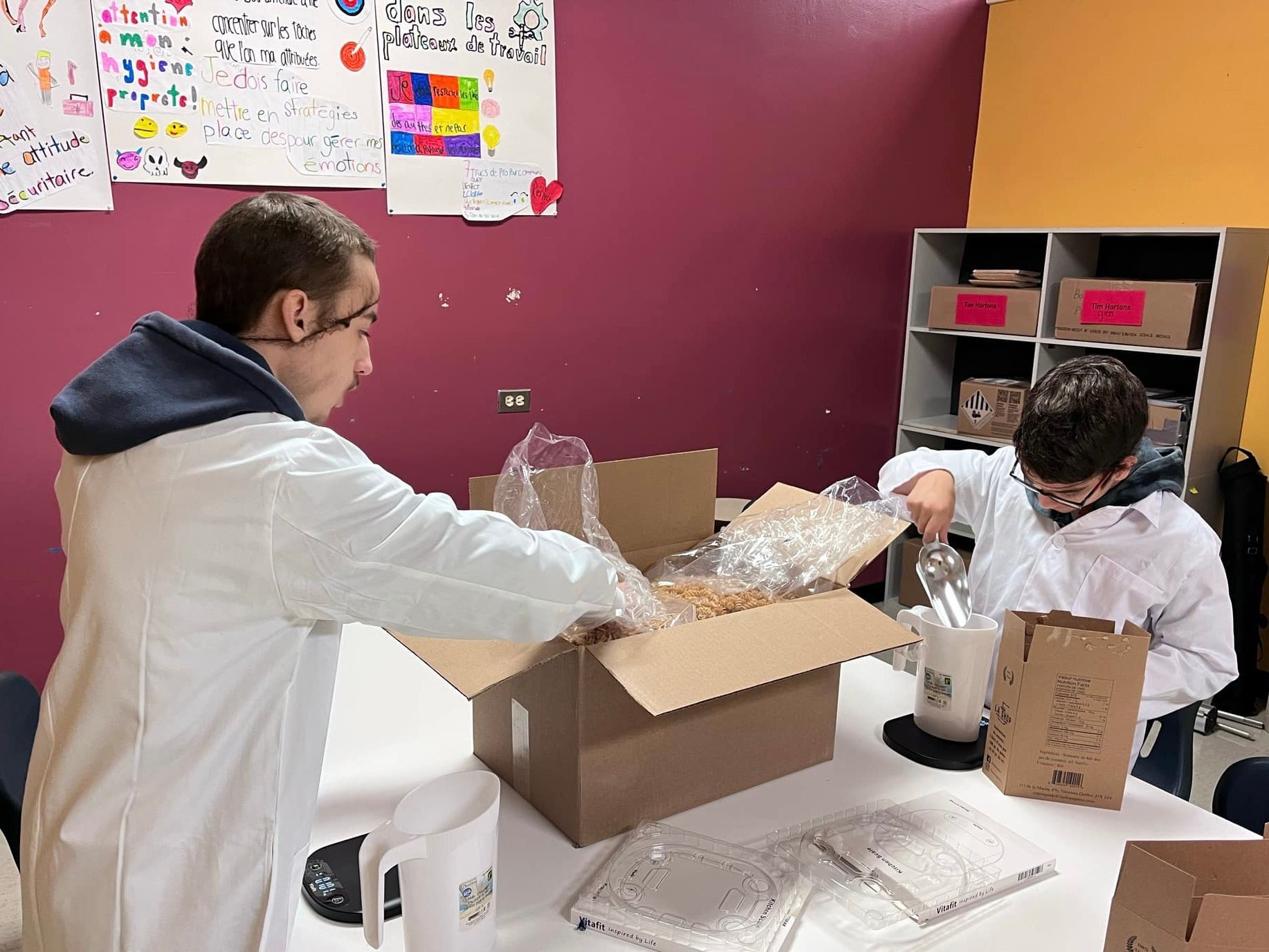 Un homme en blouse de laboratoire ouvre une boîte en carton