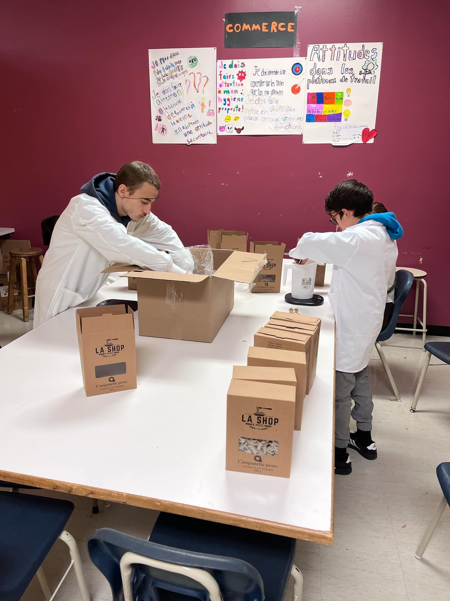 Un homme et un garçon sont assis à une table avec des boîtes dessus.