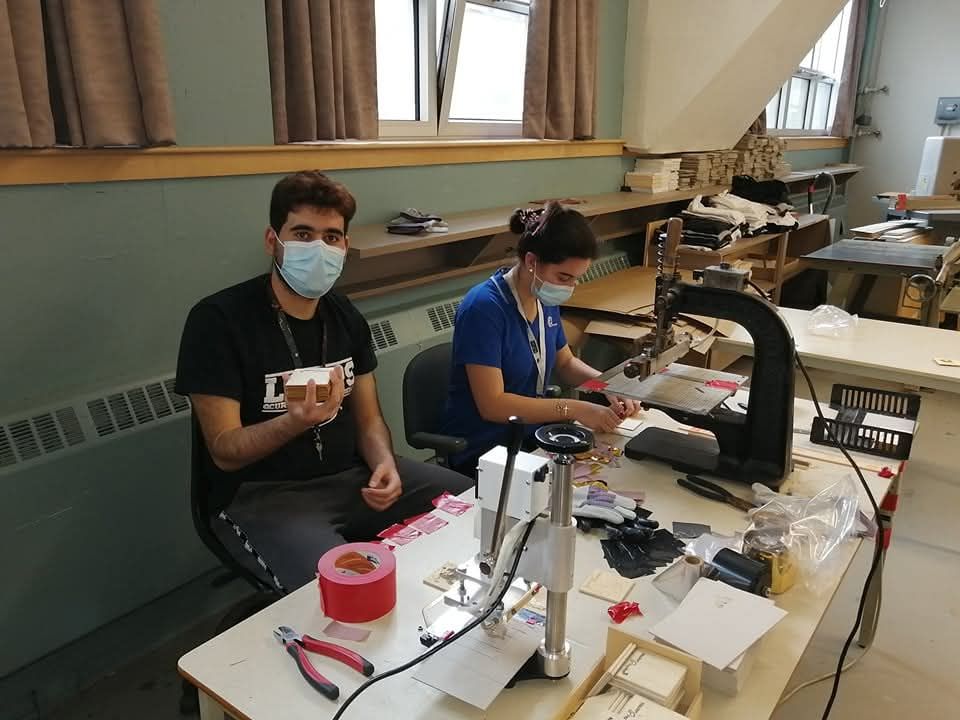 Un homme et une femme portant des masques faciaux sont assis à une table.