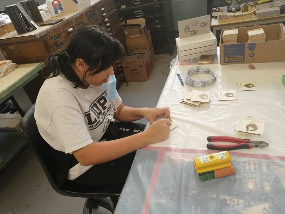 Une femme est assise à une table portant une chemise sur laquelle est écrit zip