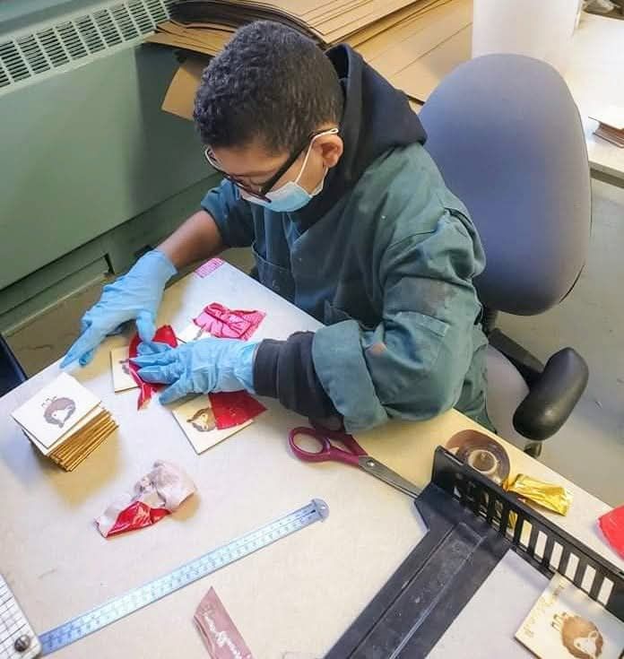 Un homme portant un masque et des gants est assis à un bureau