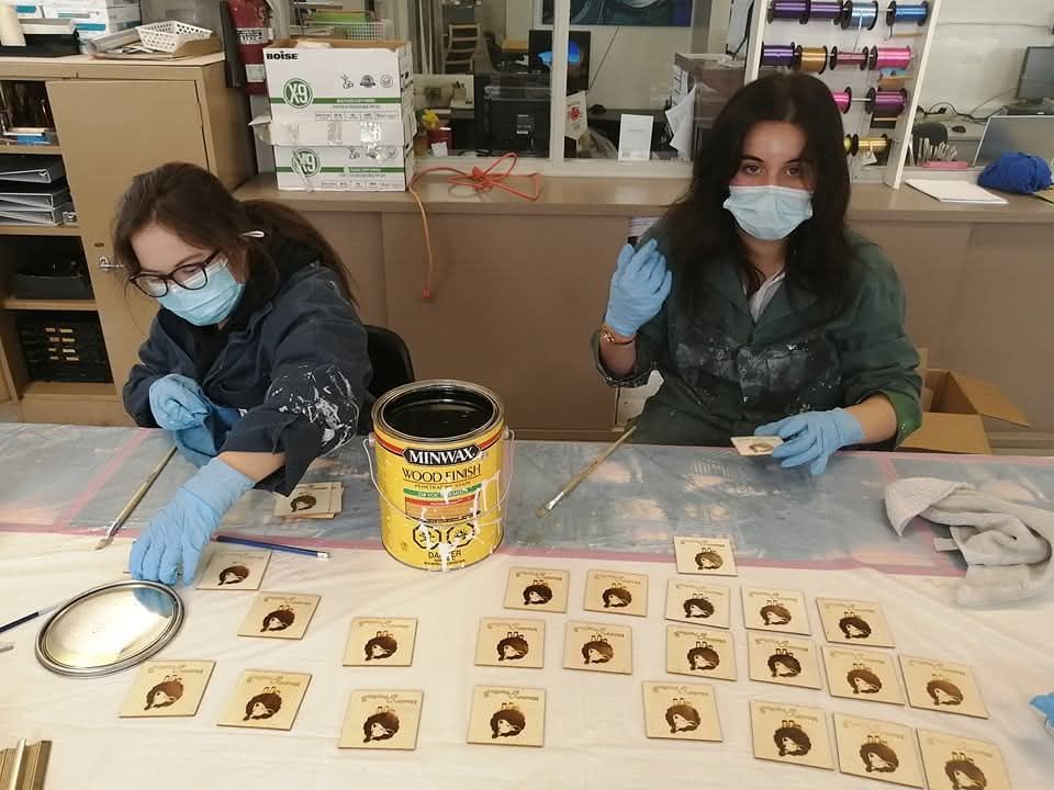 Deux femmes portant des masques et des gants travaillent sur une table