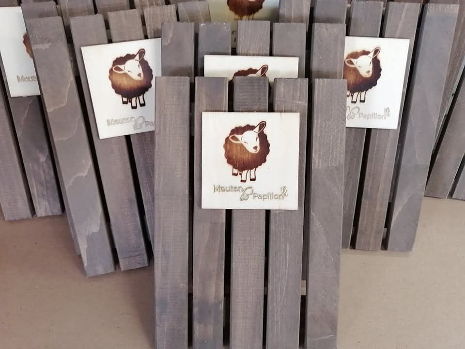 Un tas de planches de bois avec un logo de mouton dessus