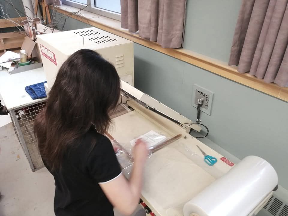 Une femme en chemise noire travaille sur une machine