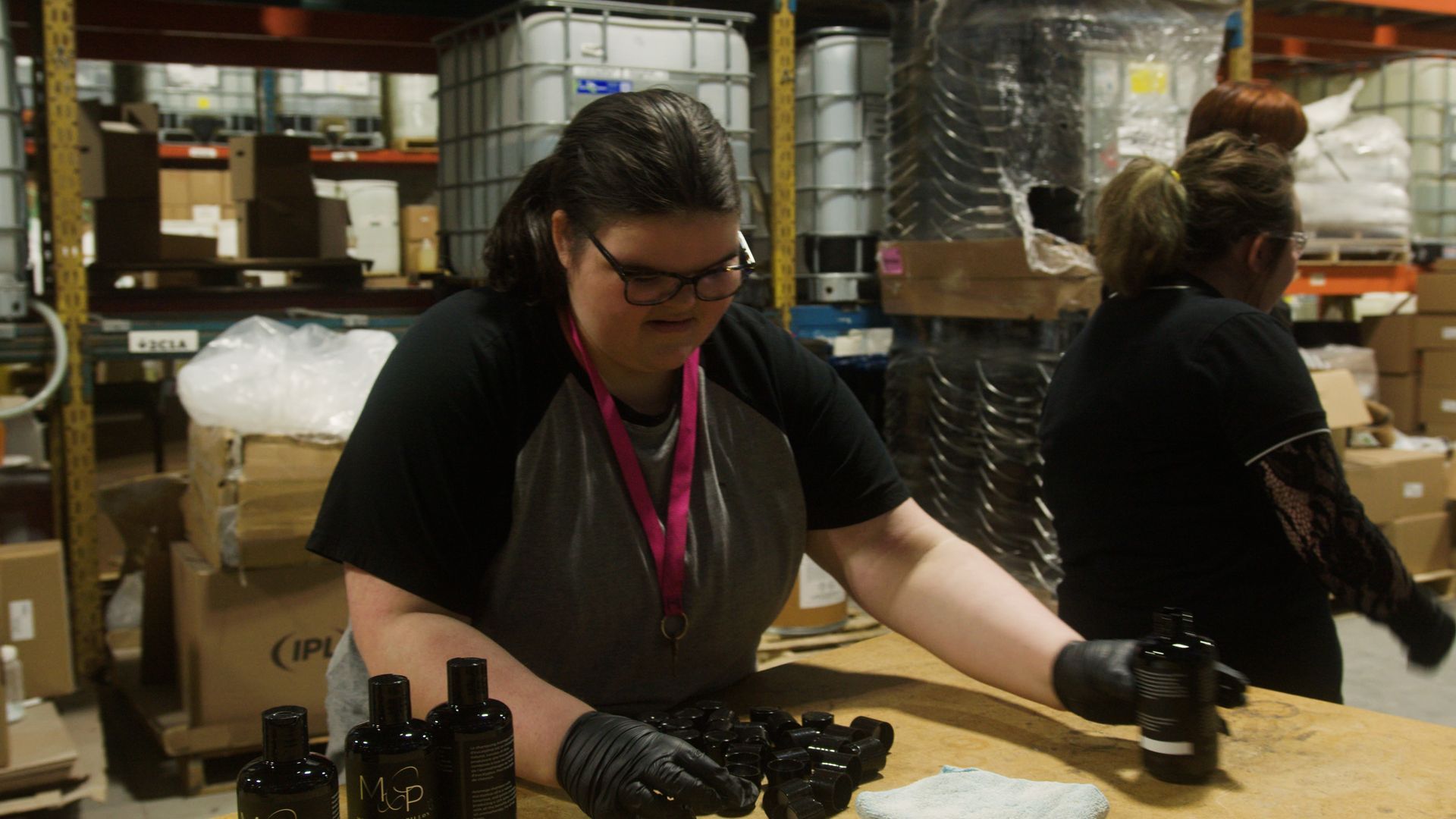 Une femme est assise à une table portant une chemise sur laquelle est écrit zip