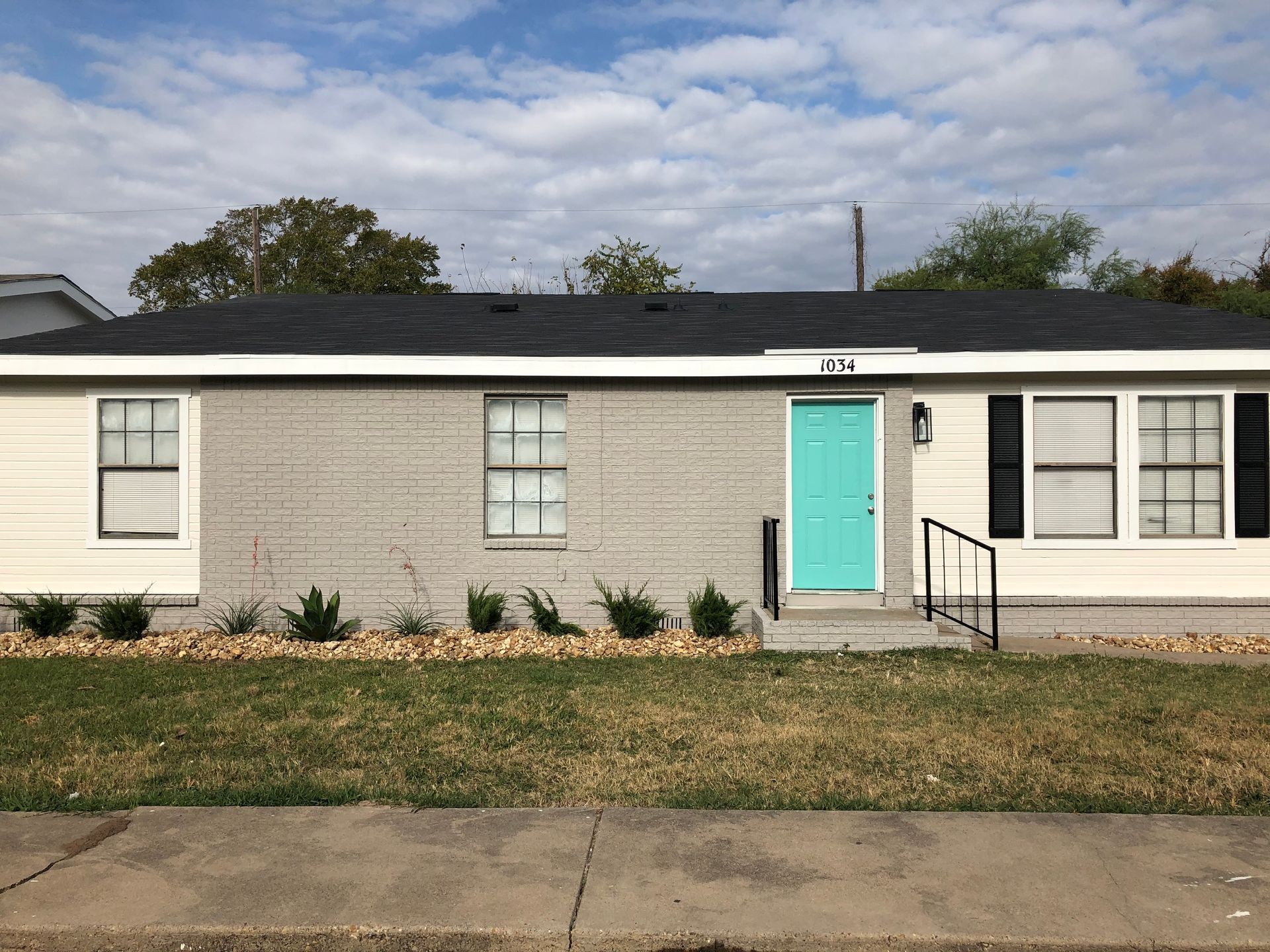 A white house with a blue door and black shutters