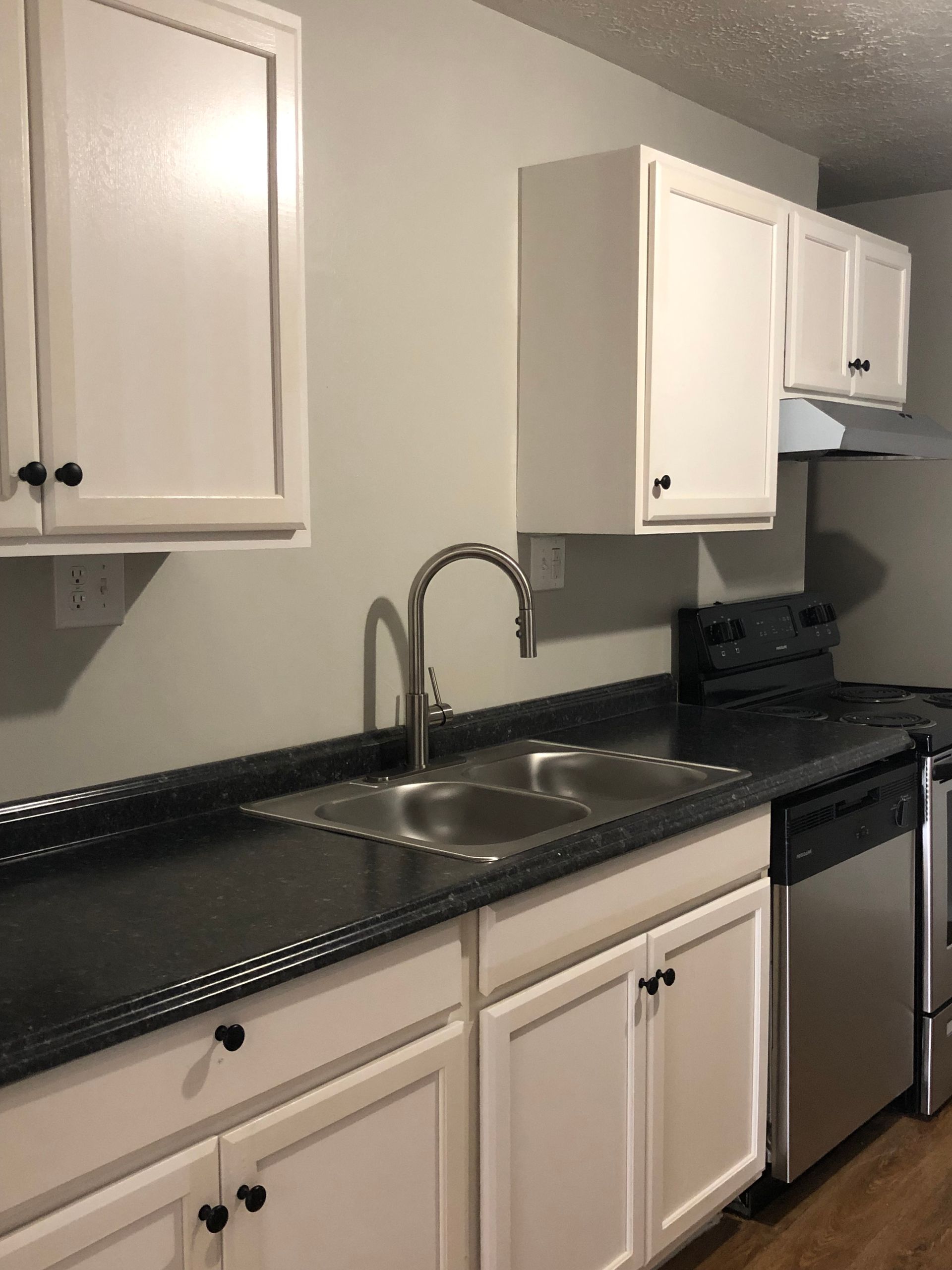 A kitchen with stainless steel appliances and white cabinets