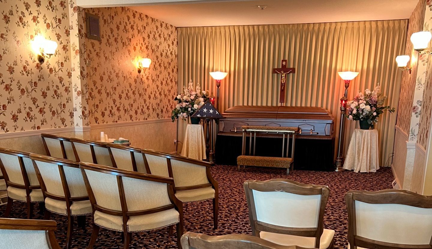A funeral home with rows of chairs and a coffin in the background.