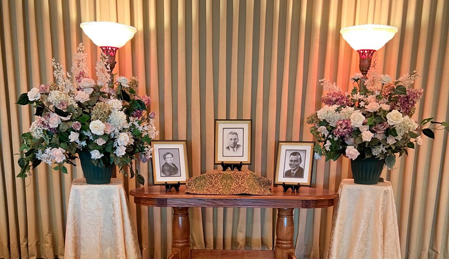 A table with flowers and pictures on it in a room.