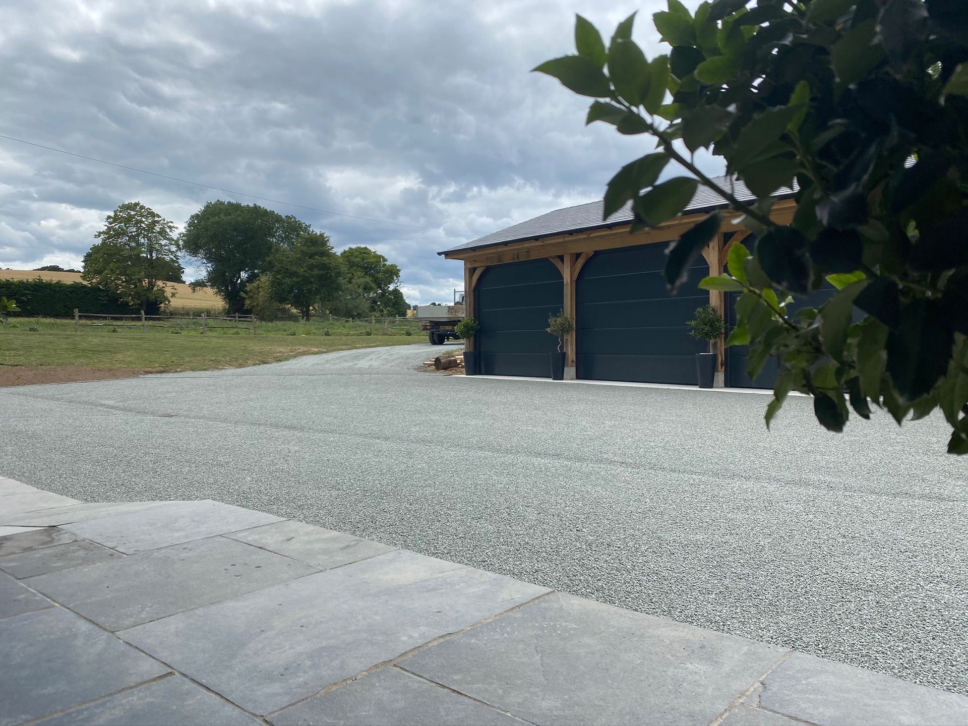 A driveway with gravel and a garage in the background