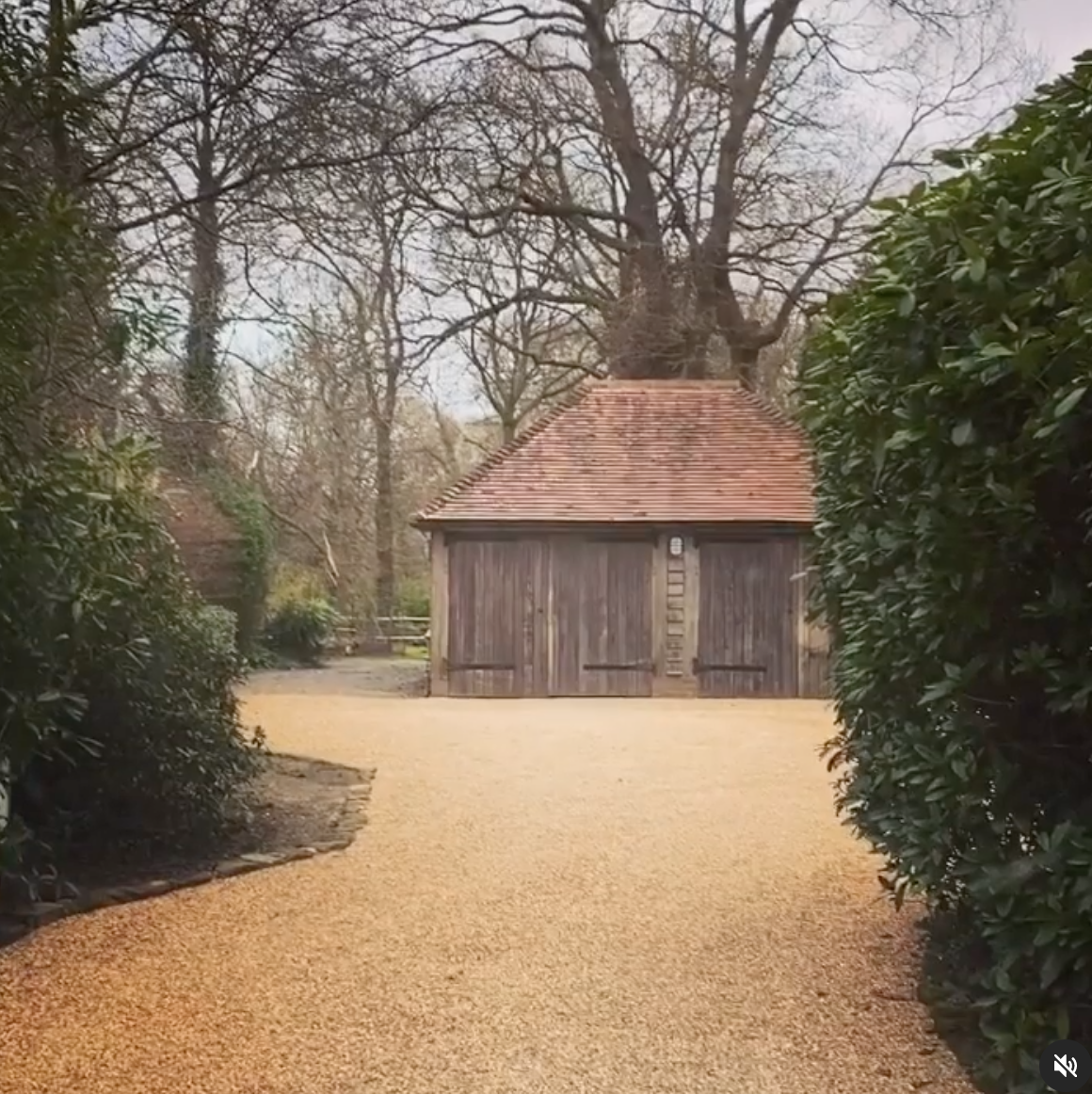 A gravel driveway leading to a wooden garage