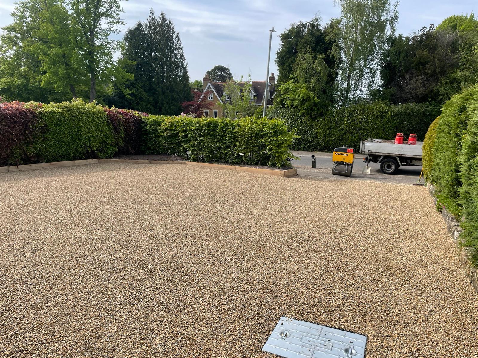 A gravel driveway with a truck parked in the background.