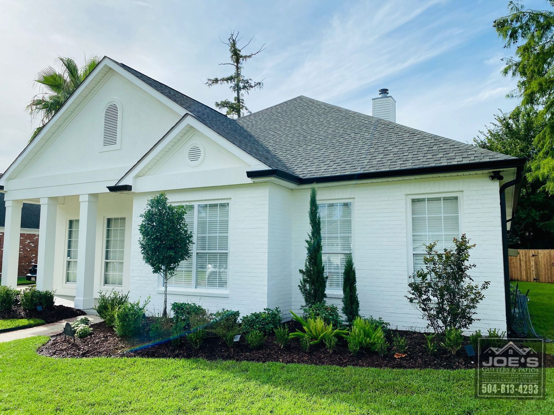 A white house with a gray roof and a lot of windows
