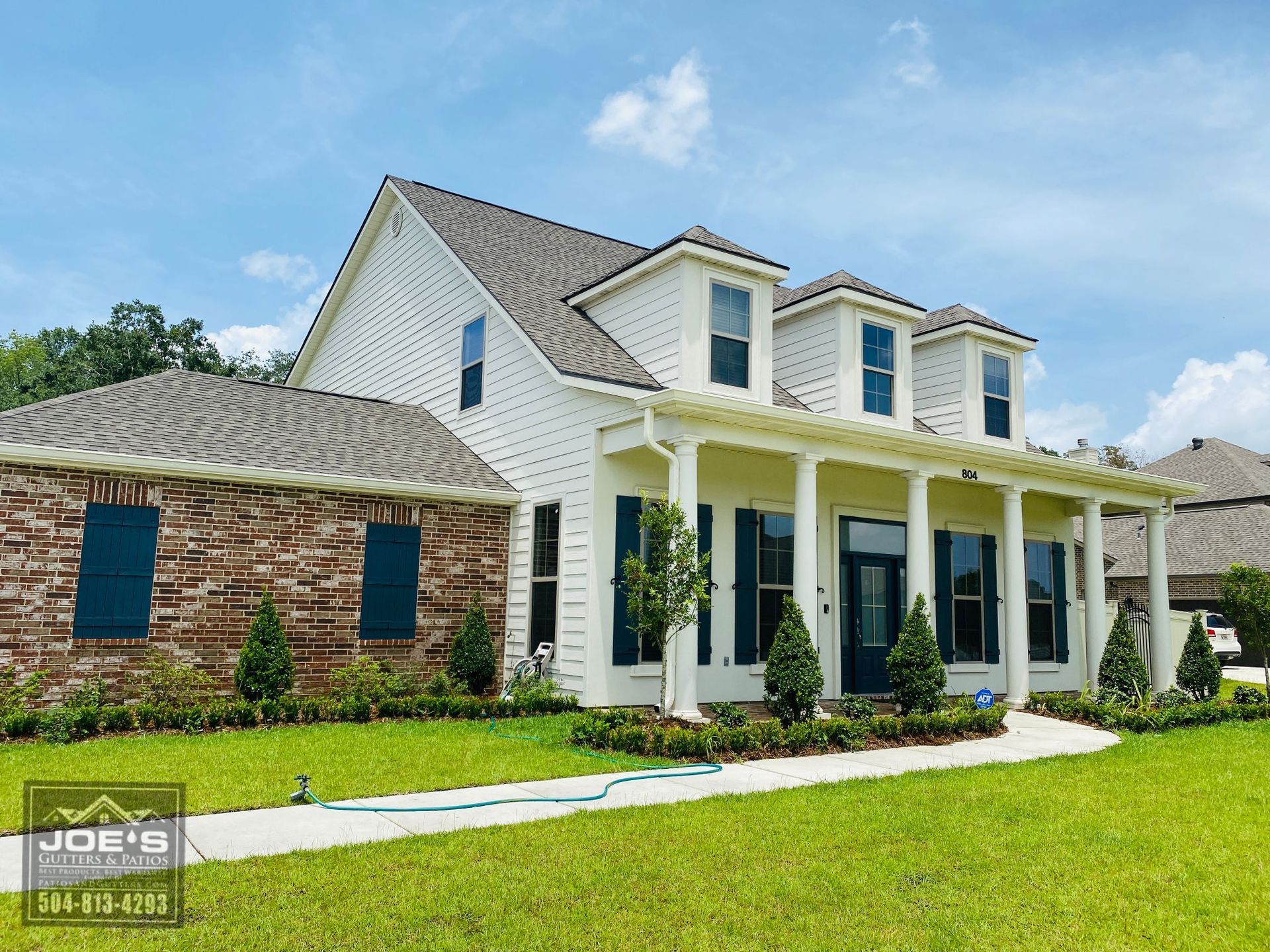 A large white house with blue shutters is for sale