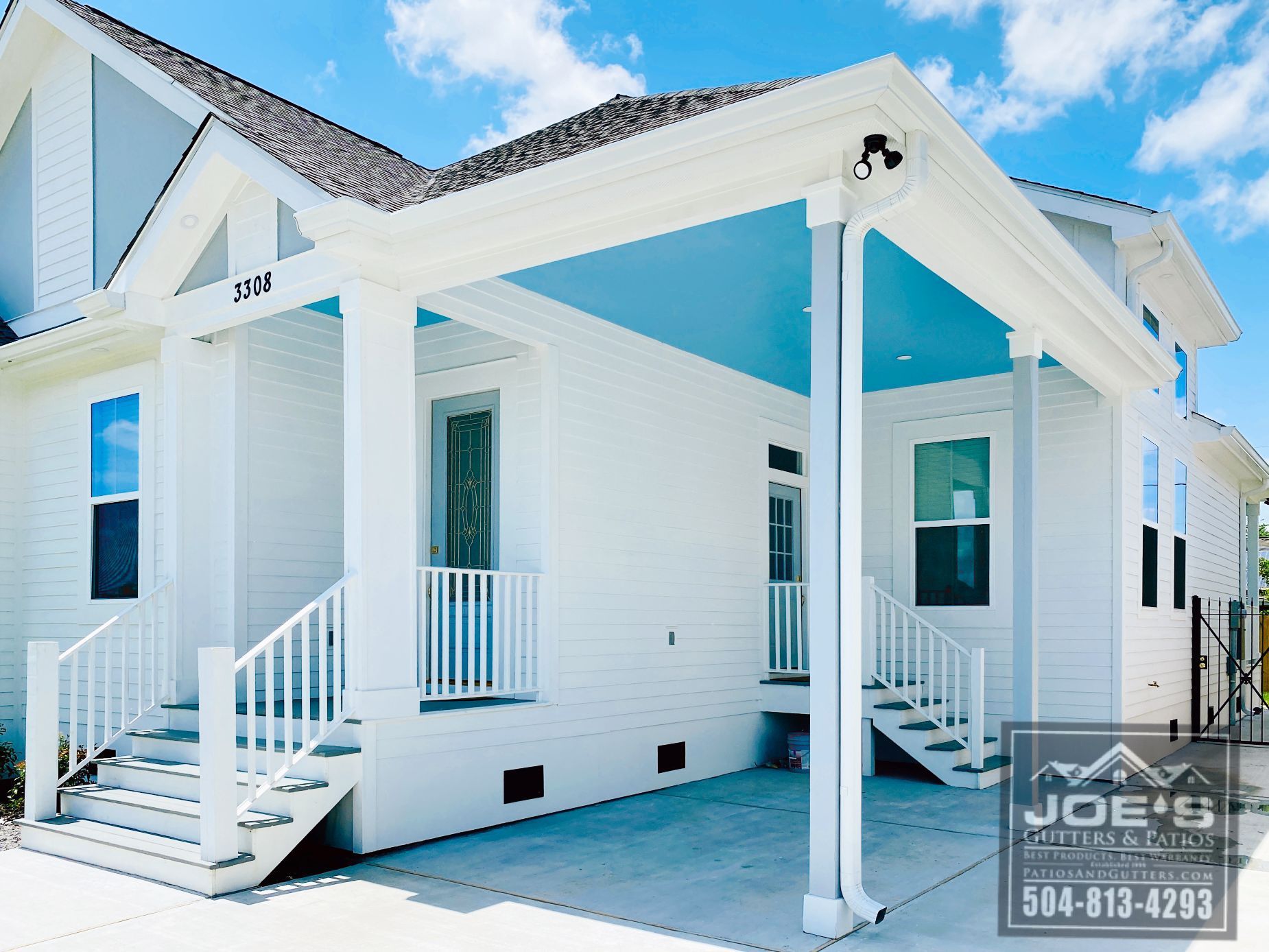A white house with a blue roof is for sale