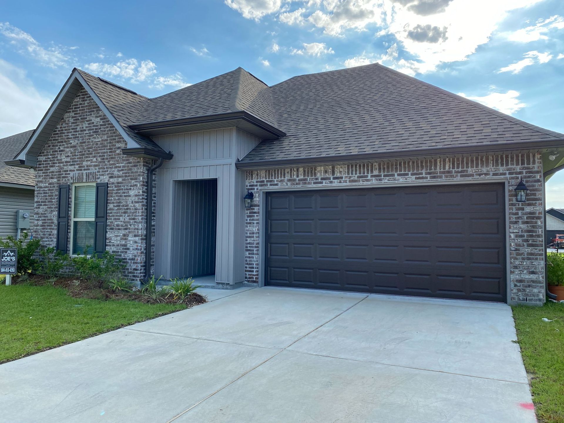 A large brick house with a large garage door.