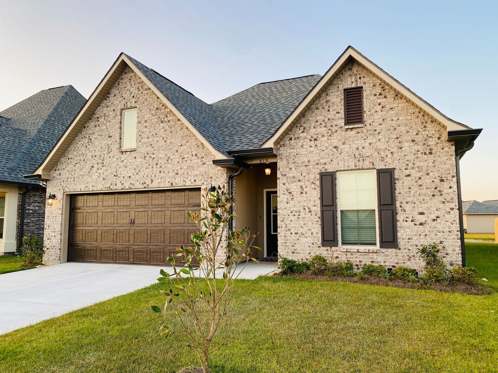 A large brick house with a large garage and a large window.