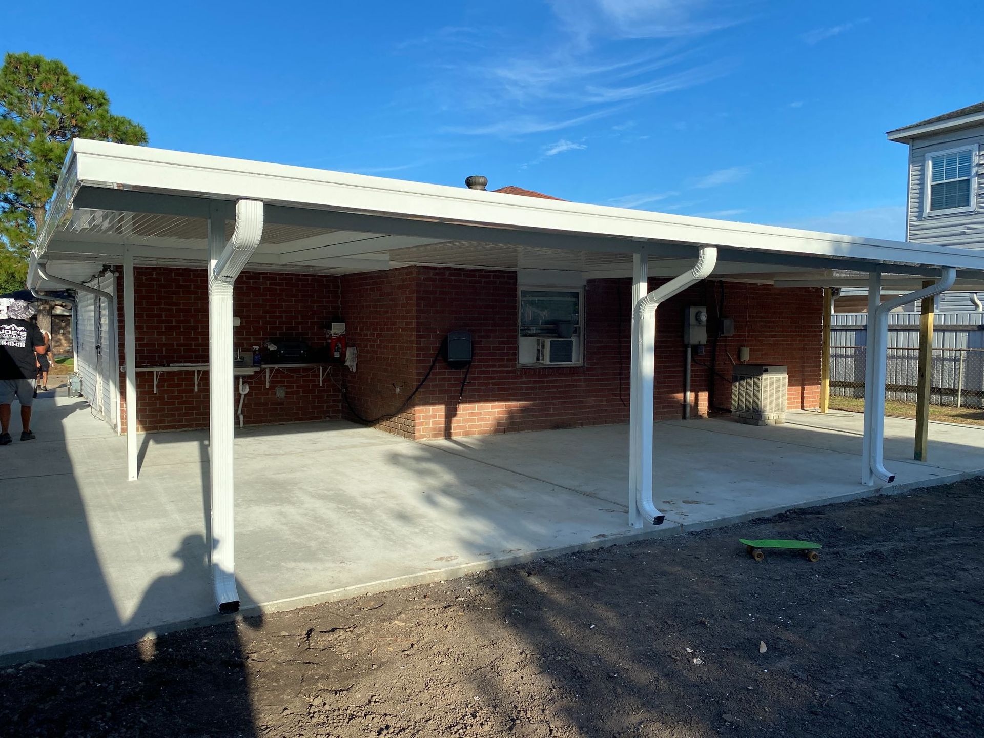 A brick house with a white awning over the driveway.