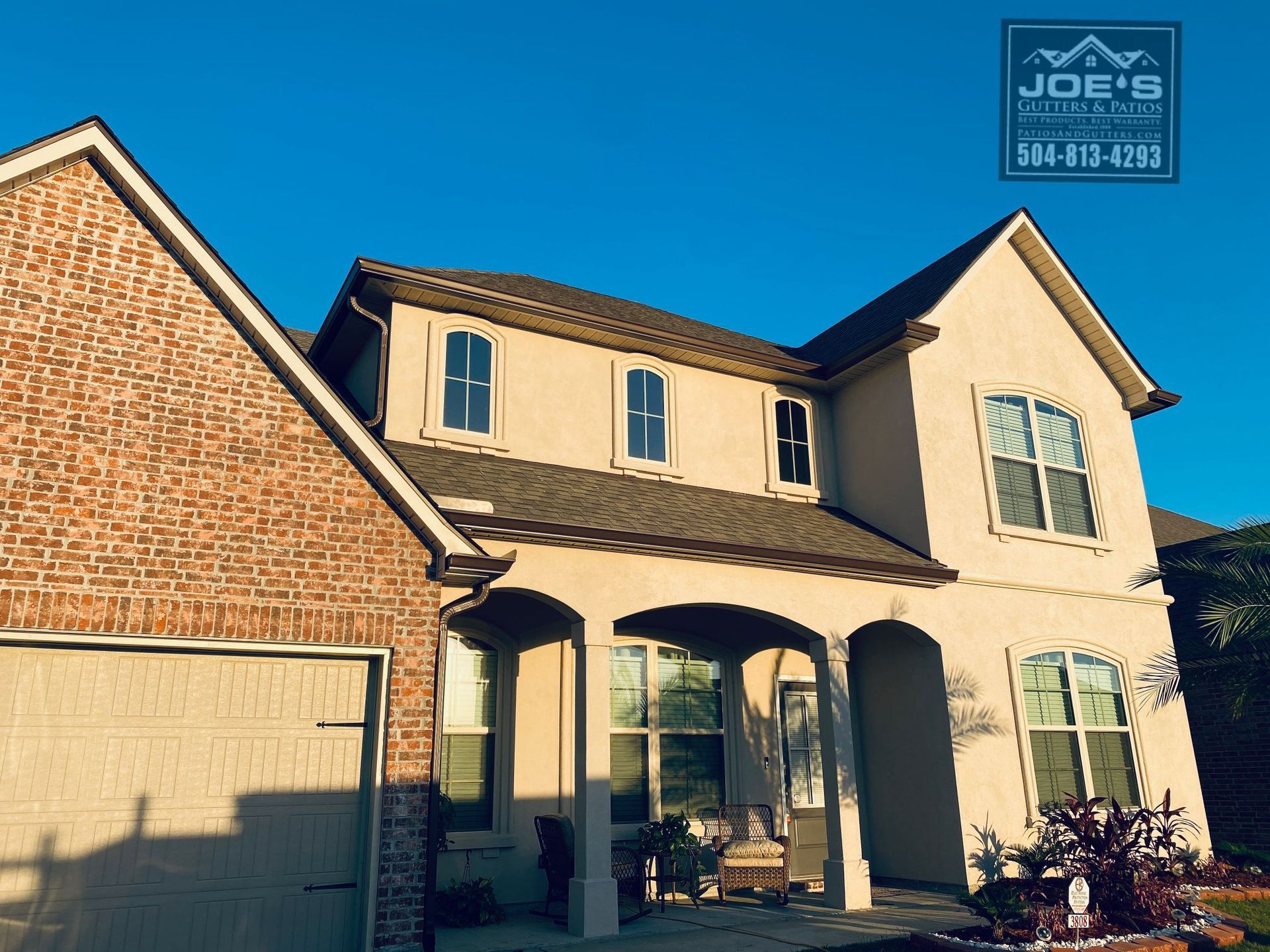 A large brick house with a garage and a sign that says joe 's