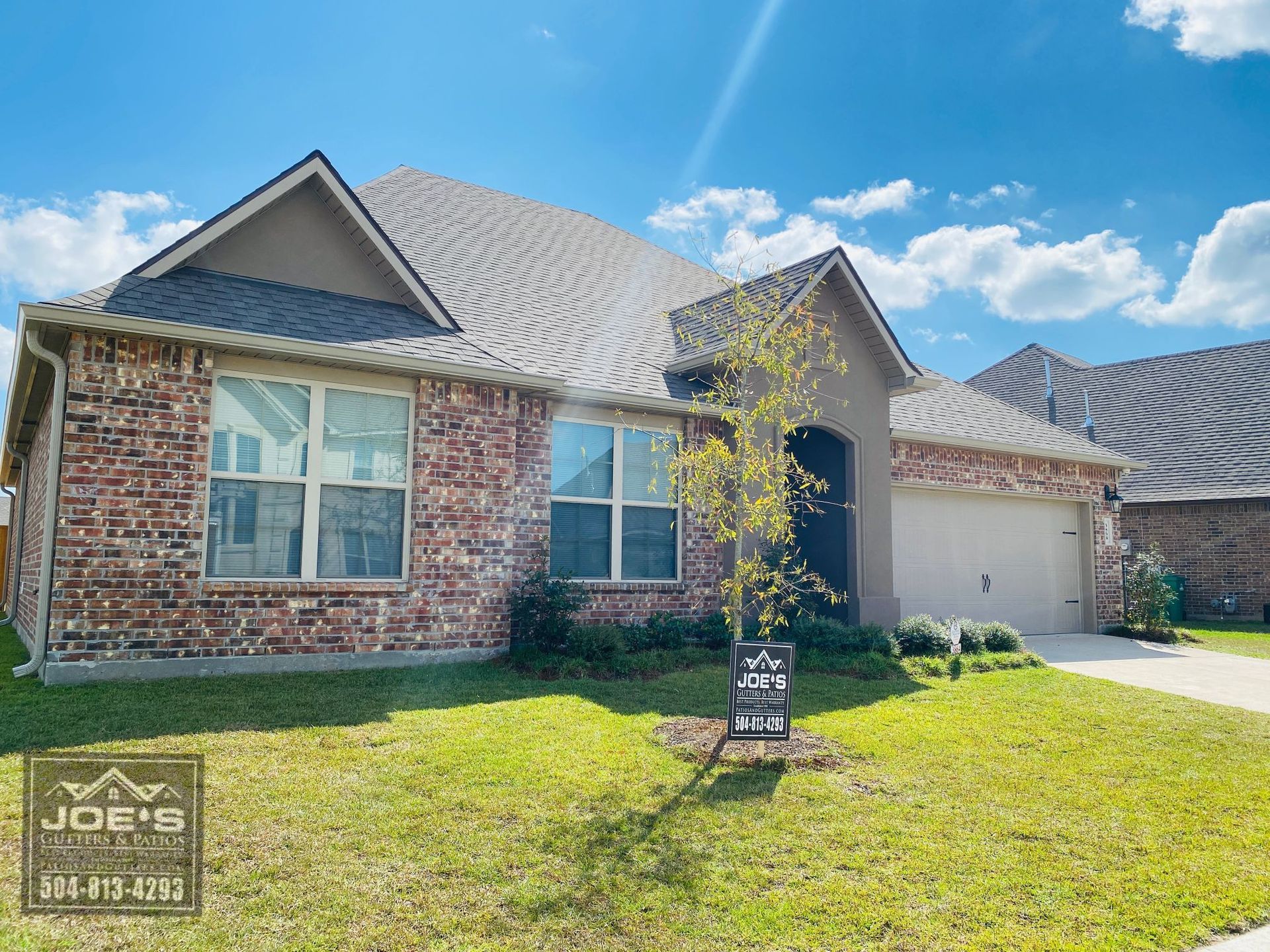 A brick house with a gray roof is for sale.