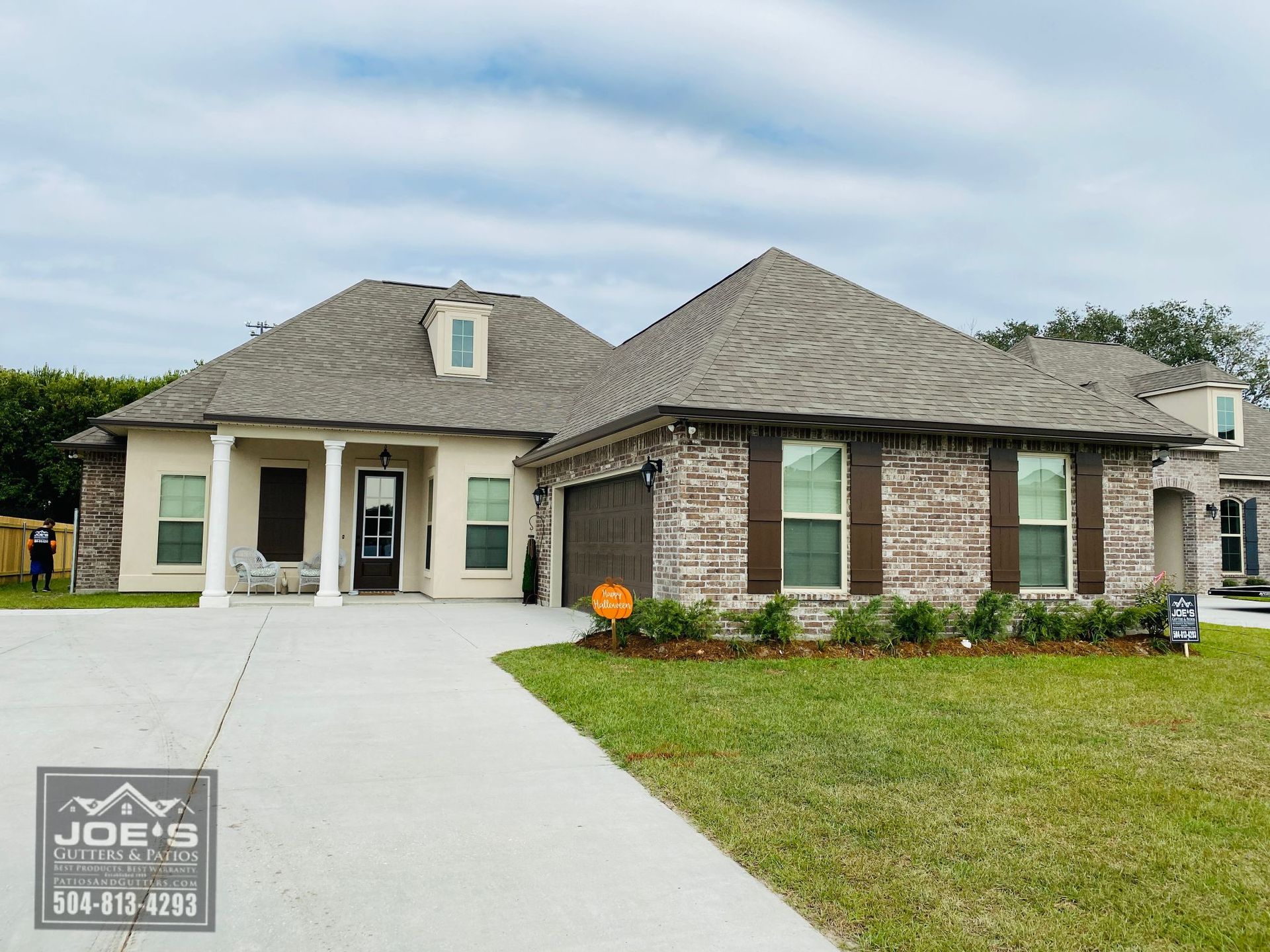 A large brick house with a gray roof is for sale.