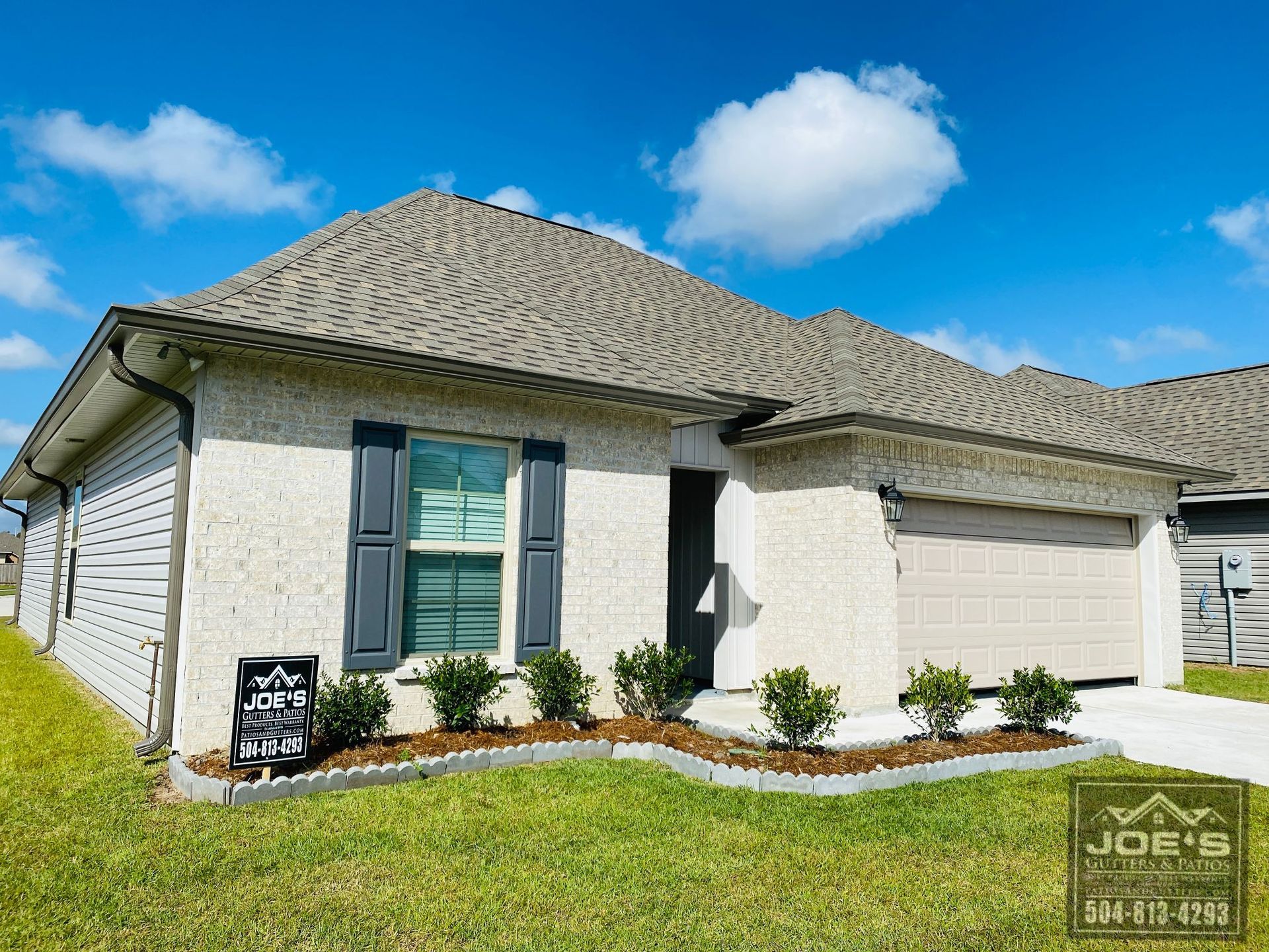 A white house with a gray roof and black shutters