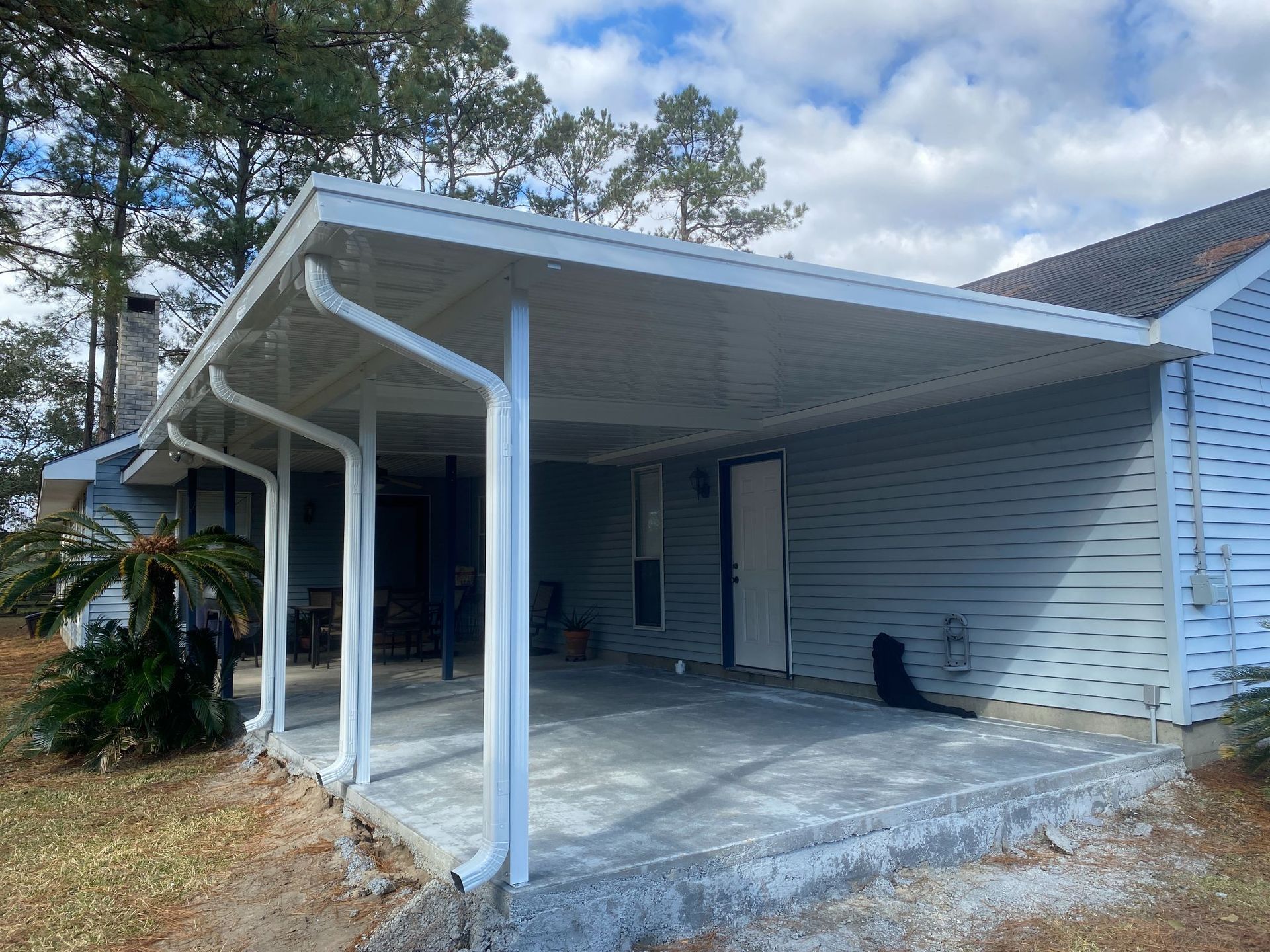A white house with a covered porch and a white roof.
