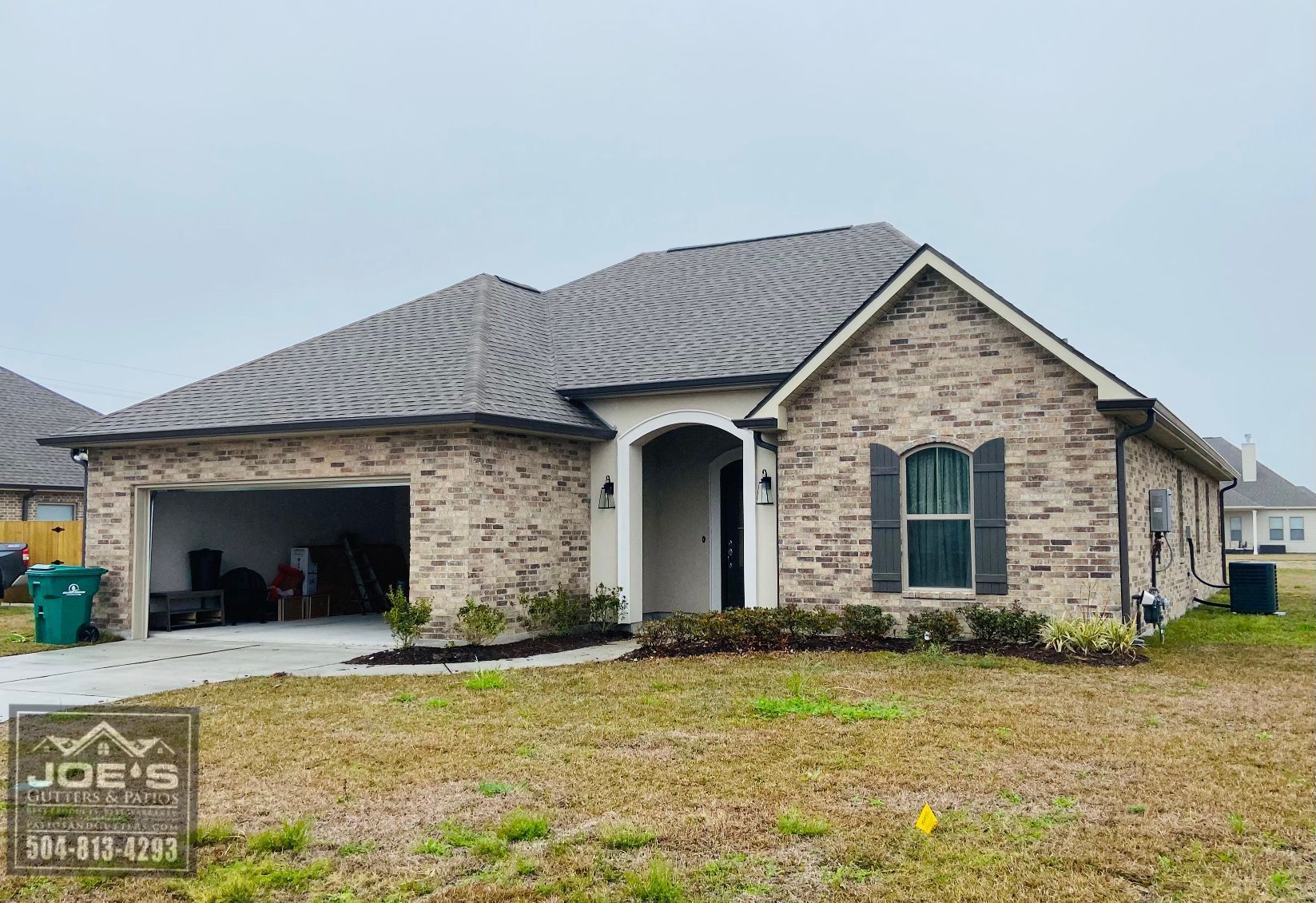A brick house with a gray roof and black shutters
