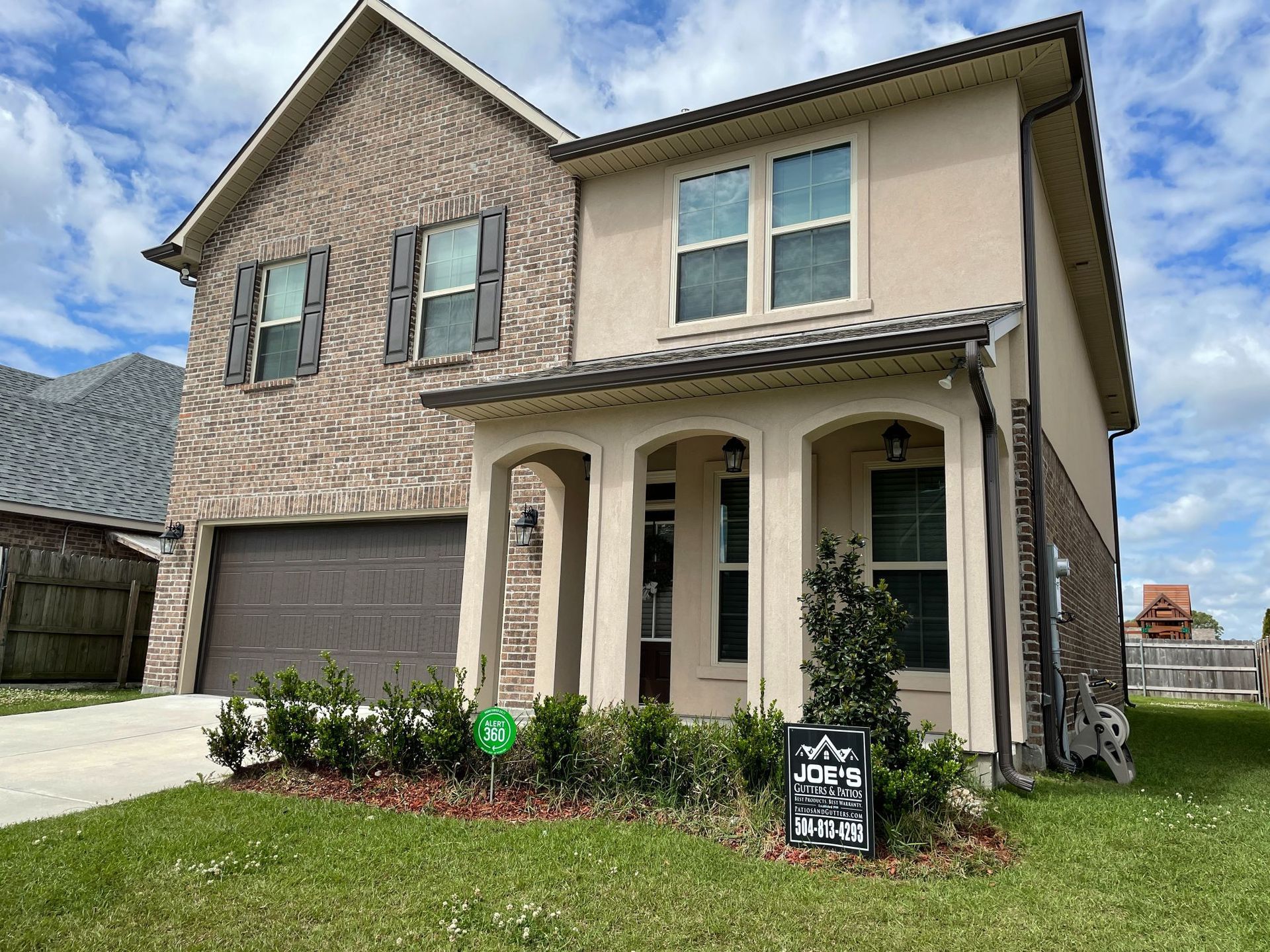 A large brick house with a sign in front of it.