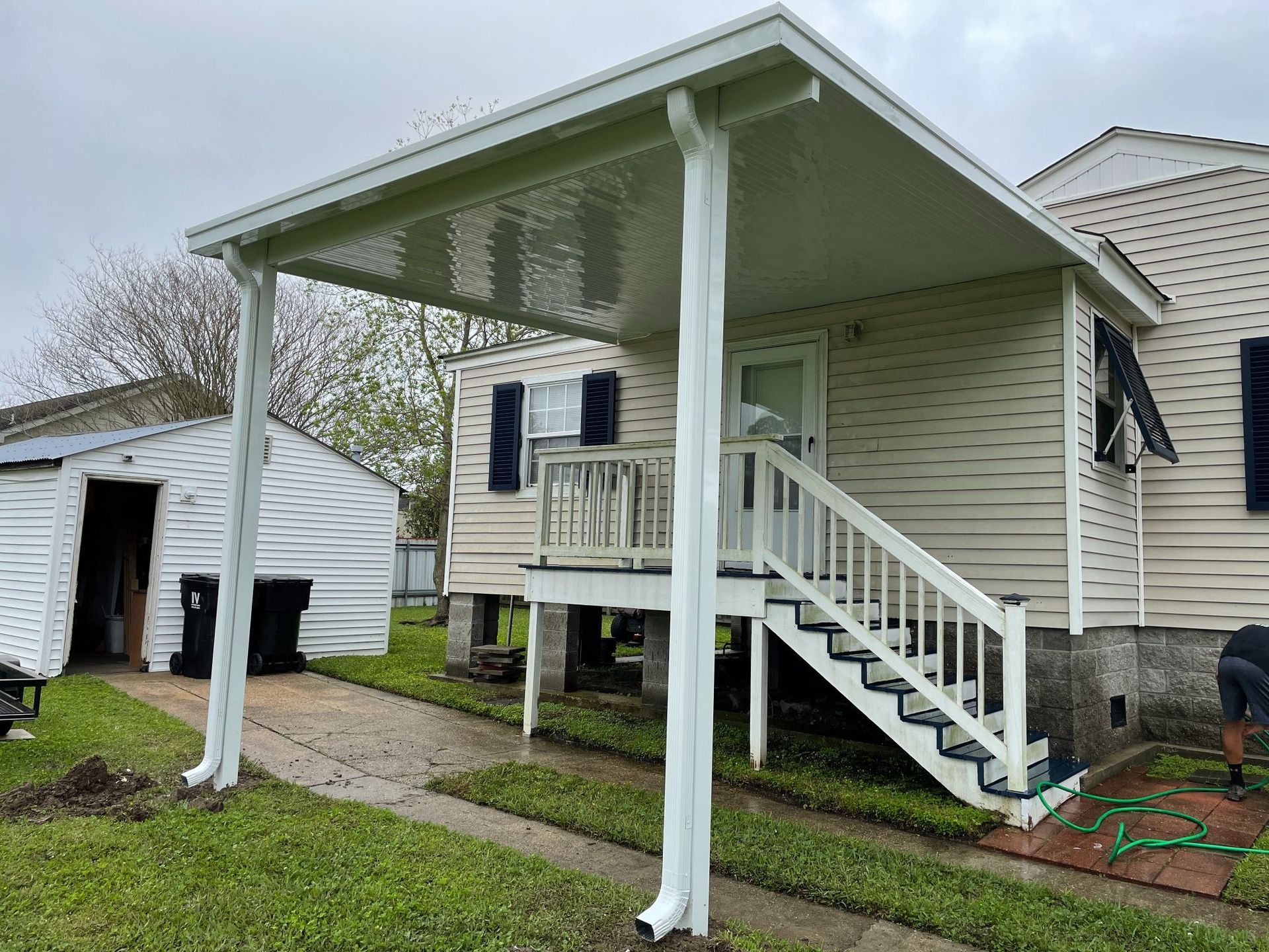 A white house with a covered porch and stairs.