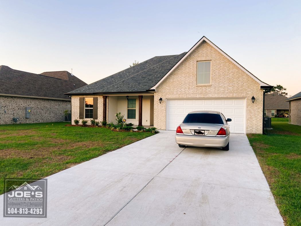 A car is parked in a driveway in front of a house.
