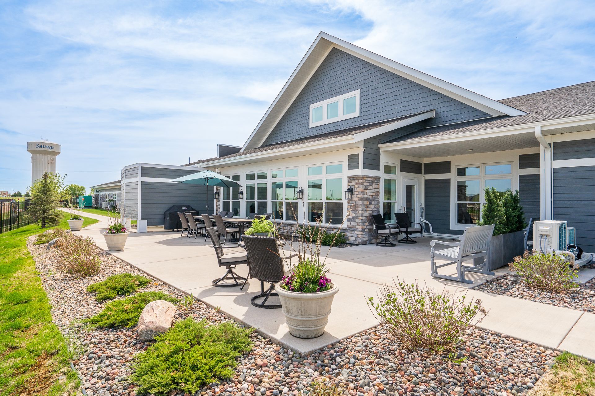 A large house with a patio and chairs in front of it.