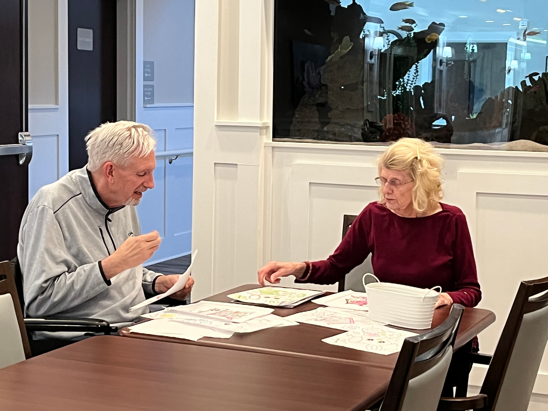 A man and a woman are sitting at a table working on Memory Care St Paul Mn
