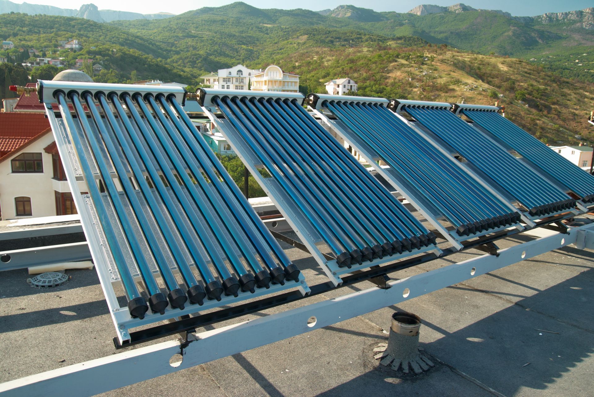 Una fila de paneles solares en un techo con montañas al fondo
