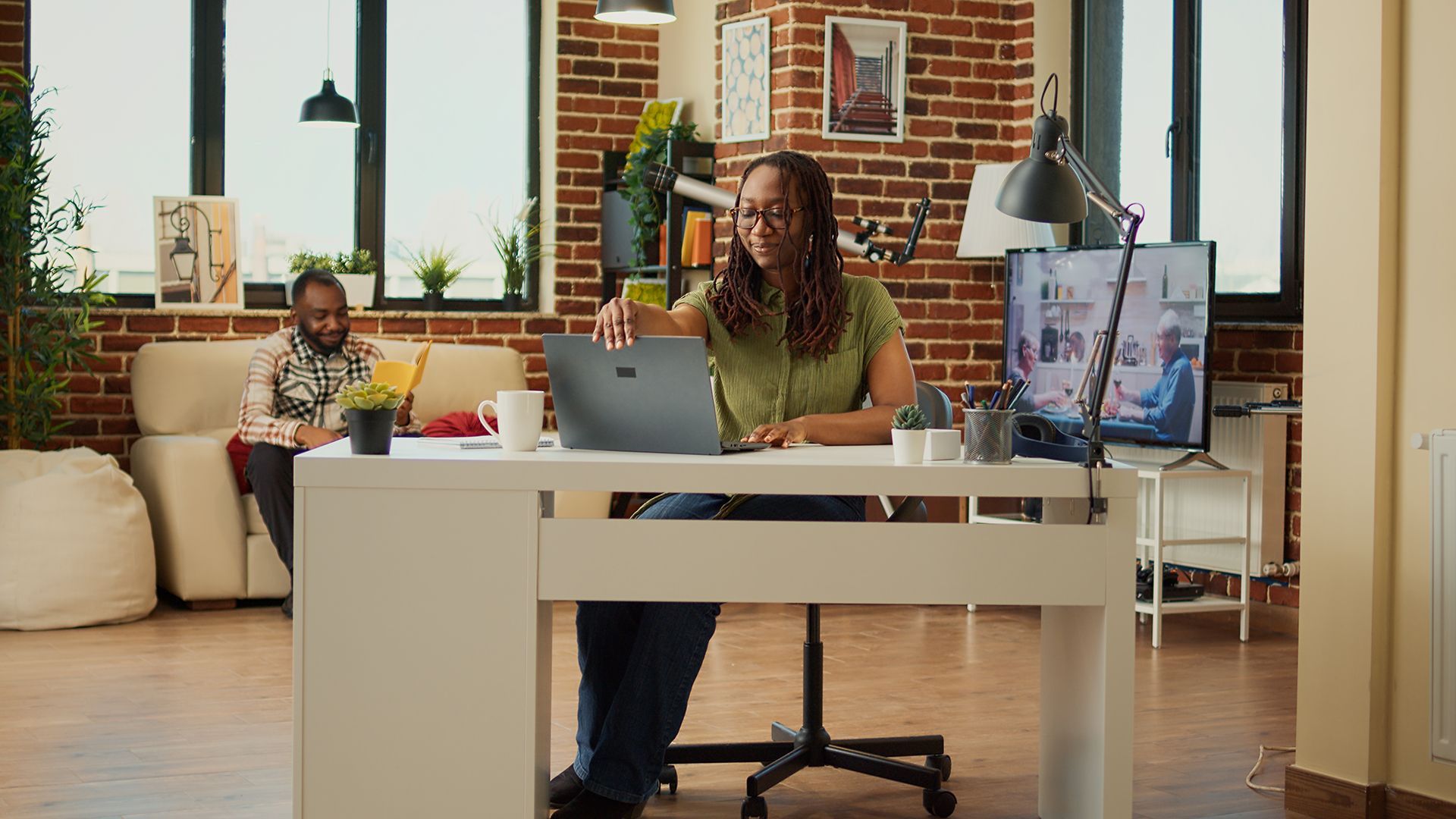 a woman is sitting at a desk using a laptop computer .