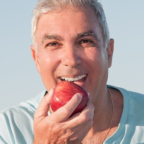 Mature Man Eating Apple — Burleigh Denture Clinic in Burleigh Heads, QLD
