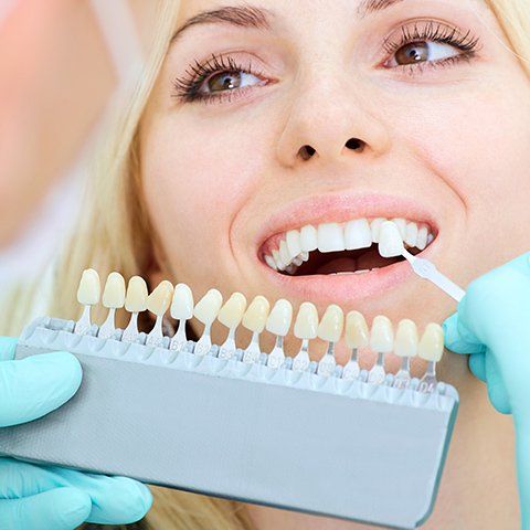 Dental Prosthetist Checking Tooth Sample — Burleigh Denture Clinic in Burleigh Heads, QLD