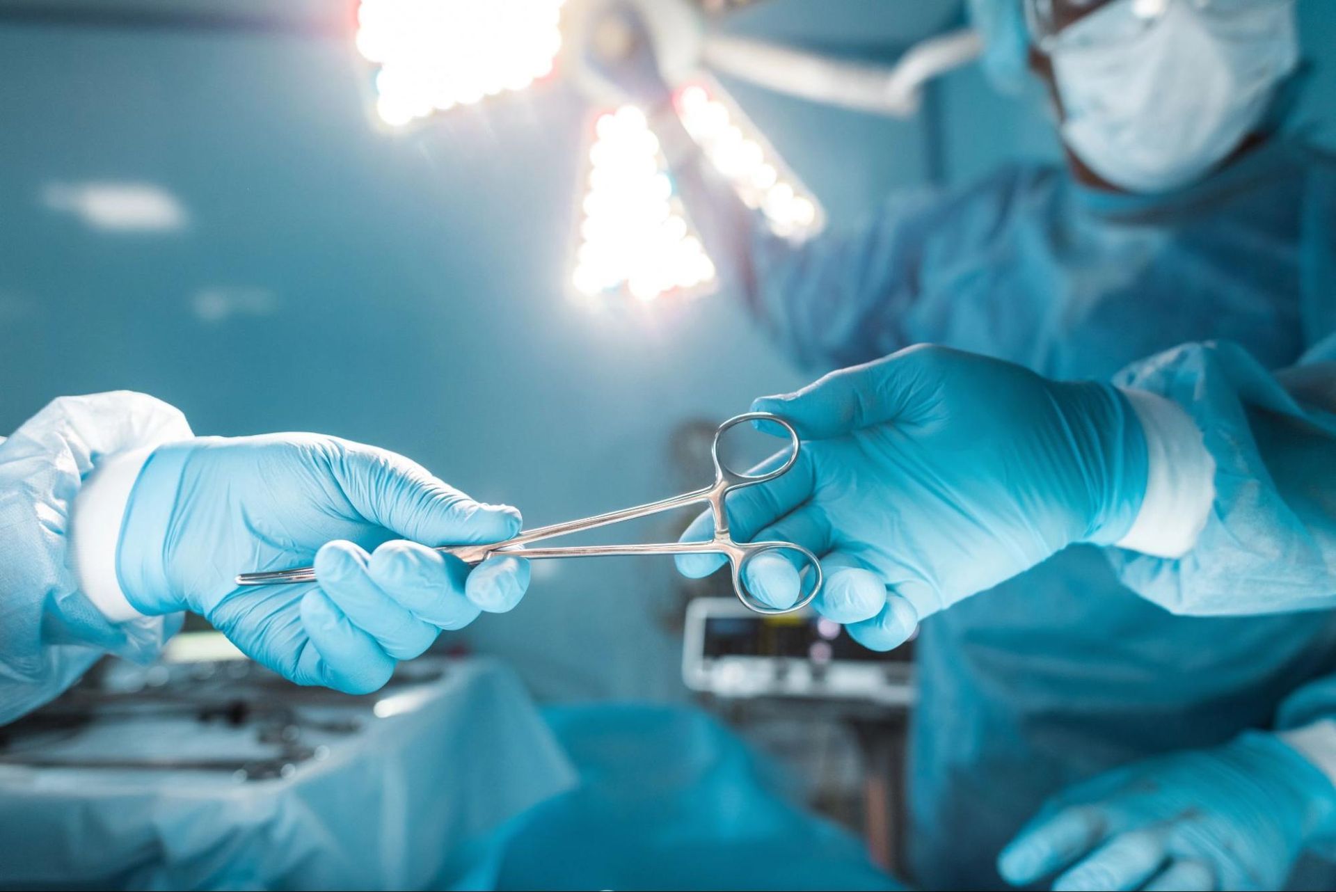 Surgeons in an operating room passing surgical instruments during a bariatric surgery procedure.